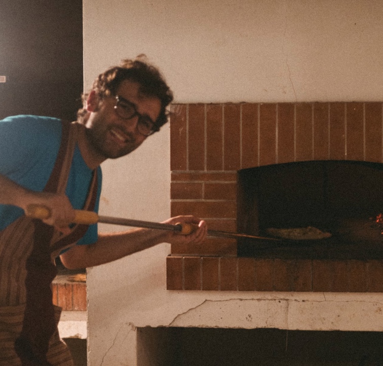 A person preparing a meal in the communal kitchen of Masseria Olga, a rural coliving space in Italy.
