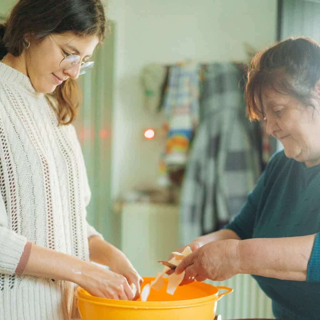 Guest cooking with local resident at Masseria Olga, engaging in cultural exchange at a coliving in Italy