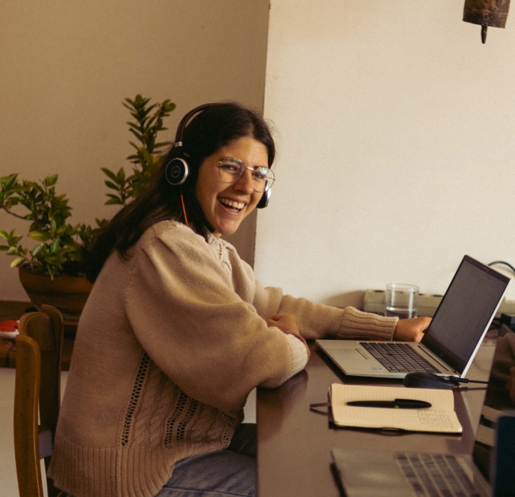 A woman working remotely in a shared coworking space at Masseria Olga coliving in Italy.
