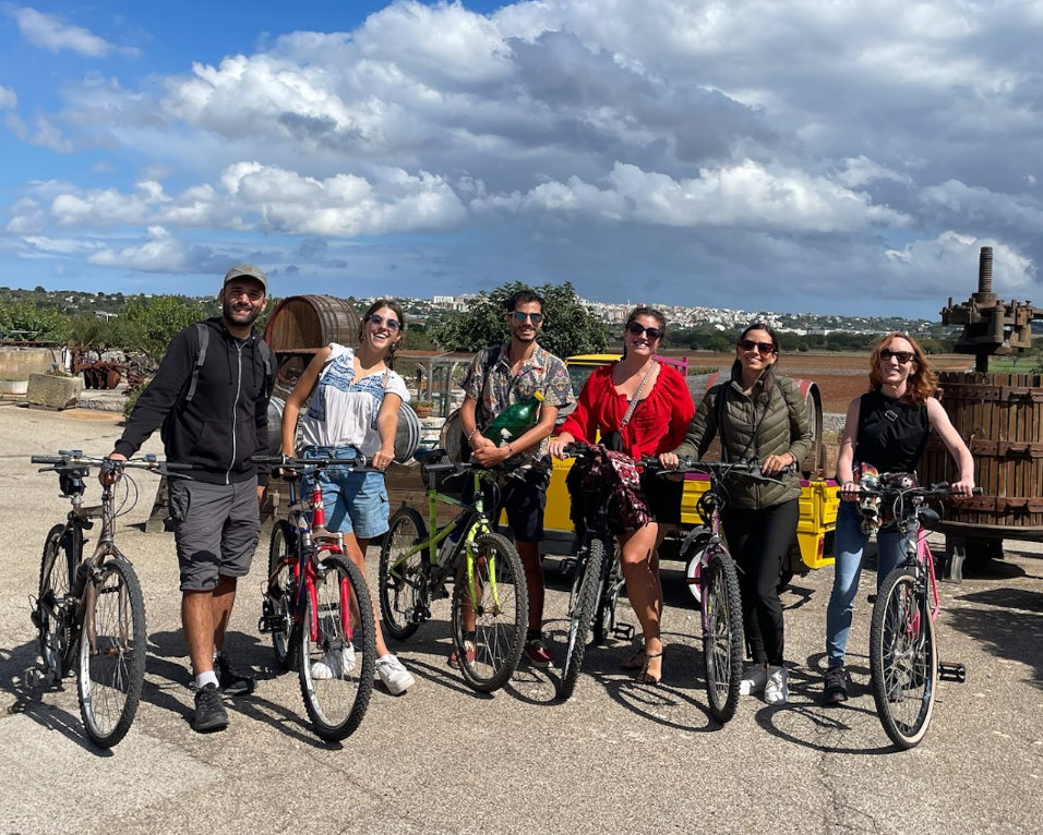 Digital nomads biking near a vineyard in Puglia, Italy