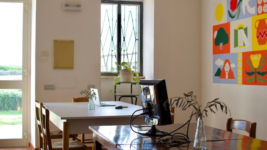 Digital nomad working in a bright coworking room inside a coliving in southern Italy