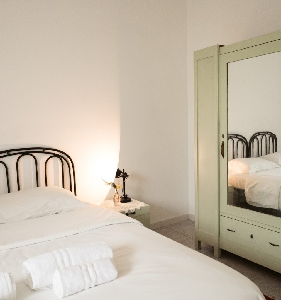 Comfortable double room with soft lighting and simple furnishings at Masseria Olga coliving in Italy.