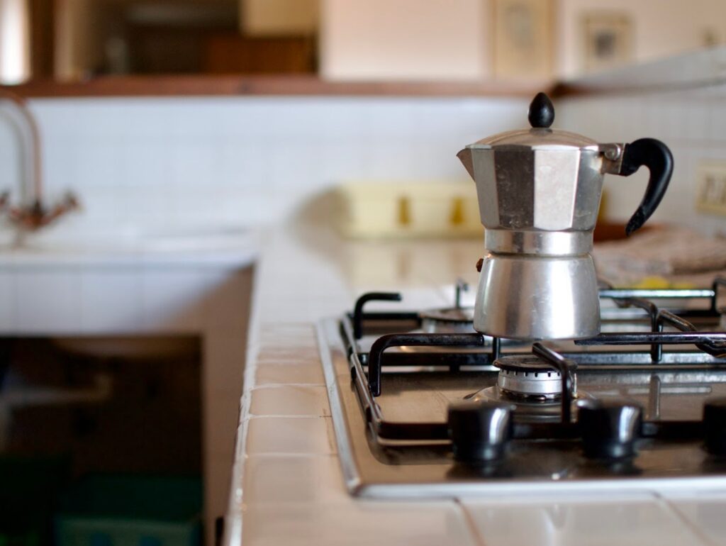Italian moka pot brewing coffee in a cozy coliving kitchen in Puglia