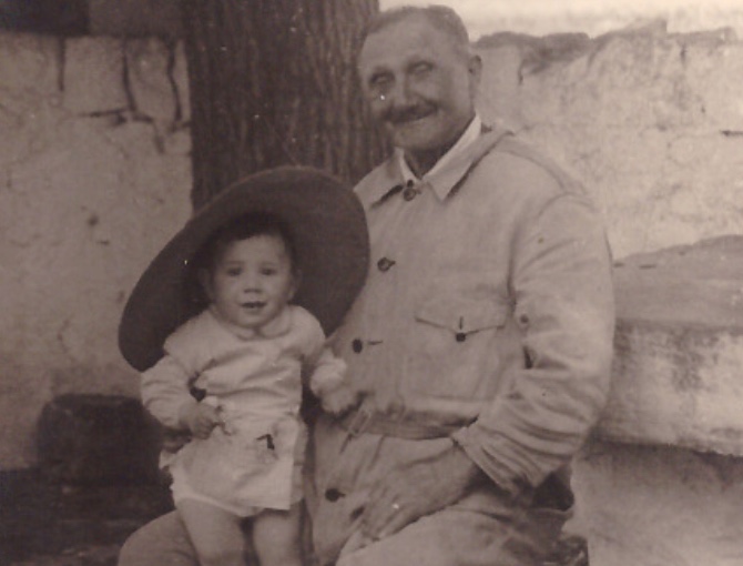 Vintage photo of Luigi Tateo sitting with a smiling toddler on his lap at Masseria Olga