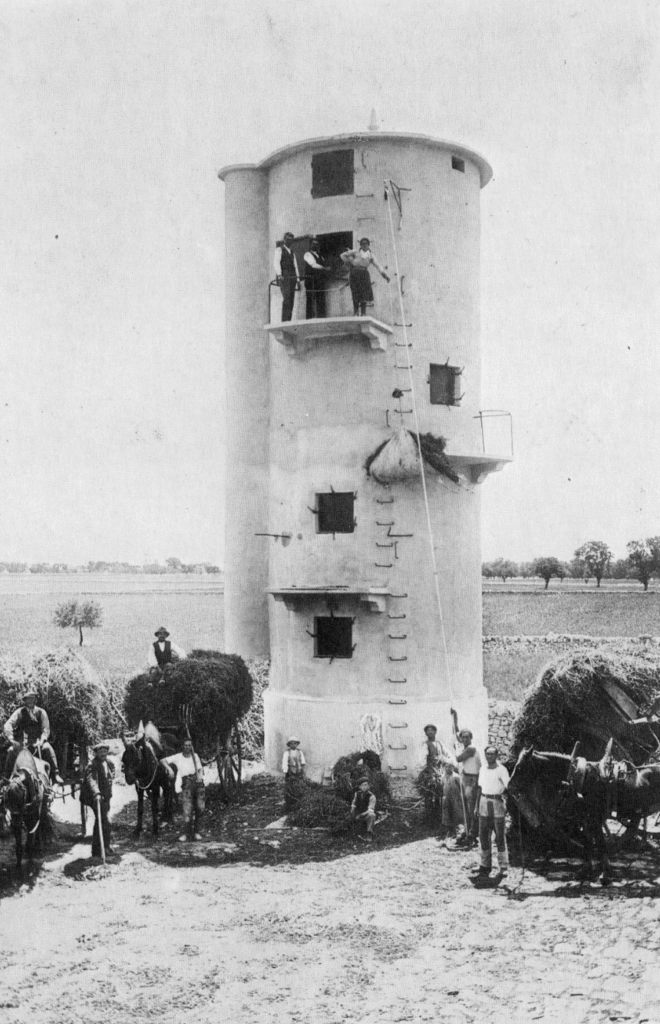 Historic photo from 1933 showing the newly built silo at Masseria Olga with workers and horse-drawn carts in front