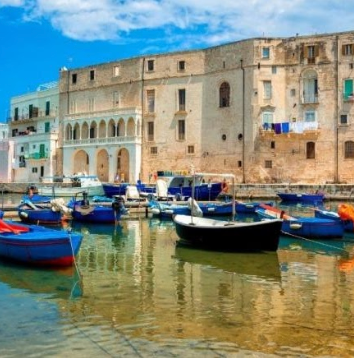 Colorful harbor and historic buildings in Monopoli, close to Masseria Olga coliving in southern Italy.