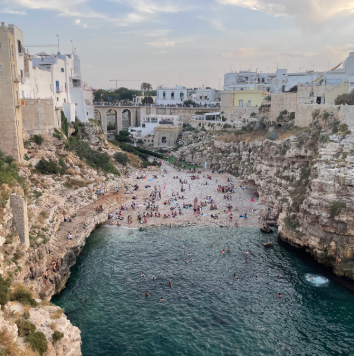 Coastal cliffs and turquoise sea of Polignano a Mare, a seaside destination near Masseria Olga coliving in Italy.