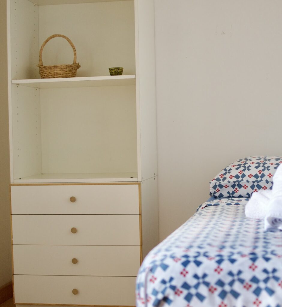 Cozy single room with minimalist decor in Masseria Olga coliving space in Italy.