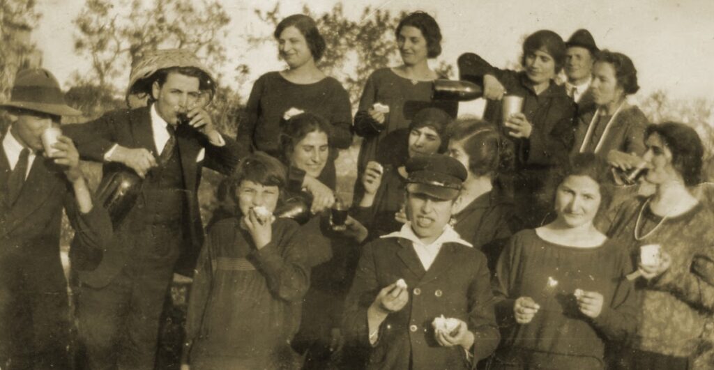 Vintage photo of farmers and workers smiling and drinking red wine after a day of work at Masseria Olga in rural Puglia
